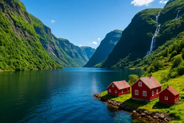Norveç fiyordunda yeşil yamaçlar ve kıyıdaki kırmızı ahşap evler